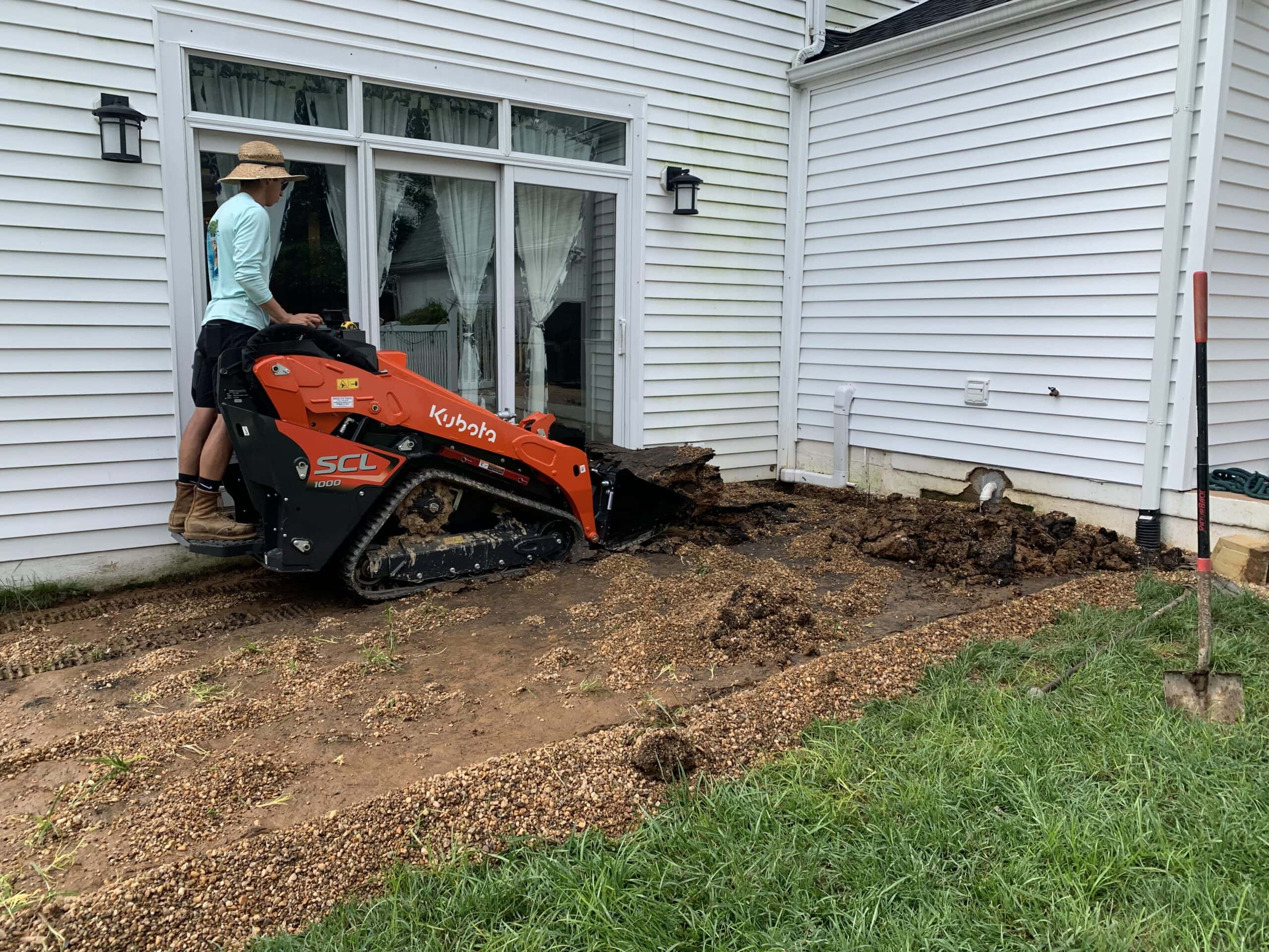 A man using a small excavator to dig up the ground.