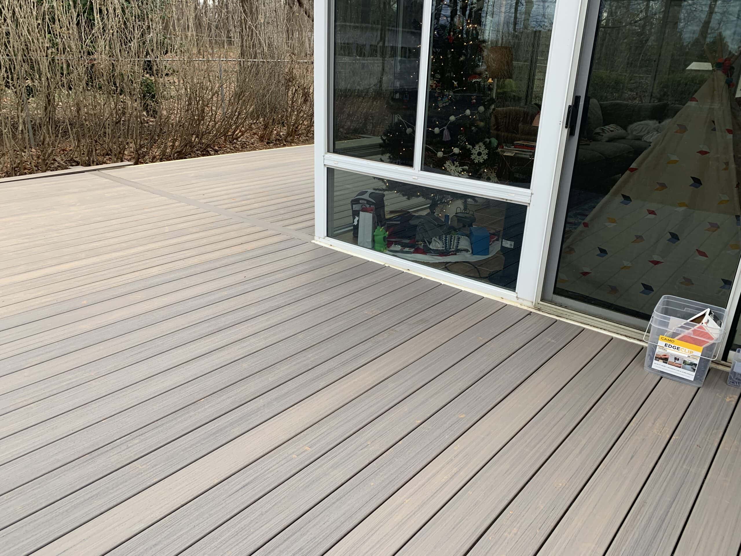A deck with a sliding door and a window.