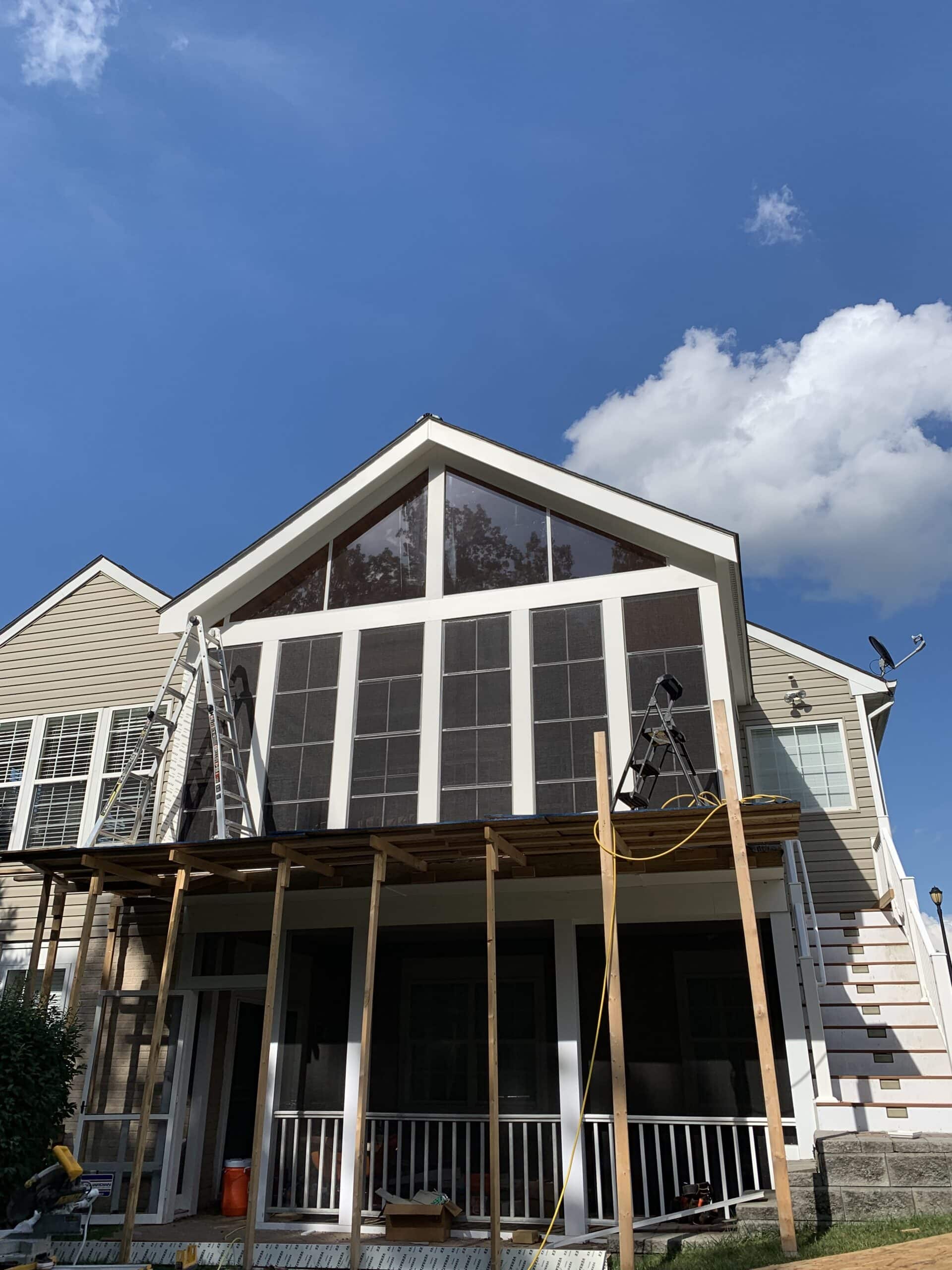 Three-season porch nearing completion with full-height tinted Sunspace windows installed