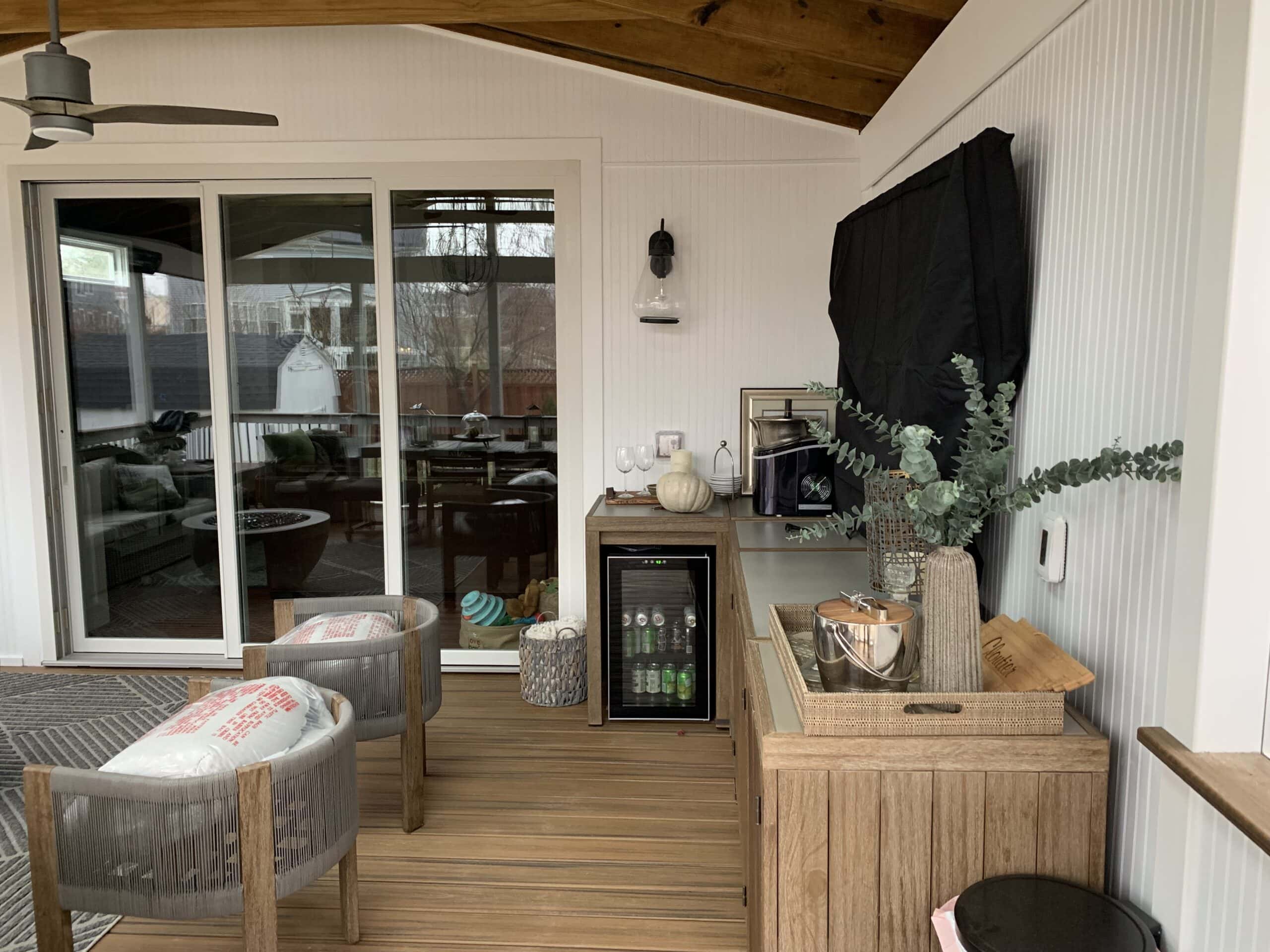 A porch with a ceiling fan and a table.