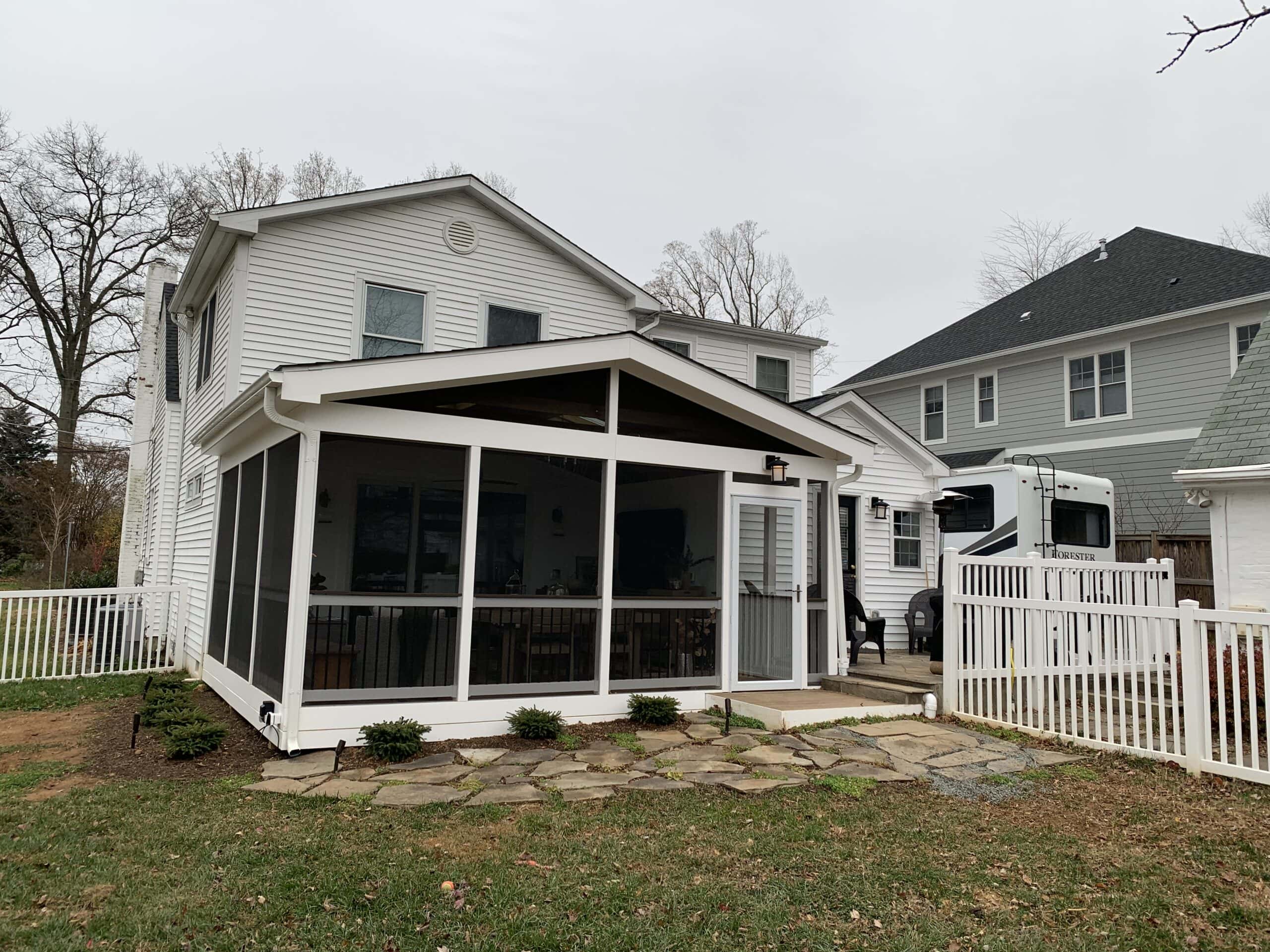A screened in porch with a white picket fence.