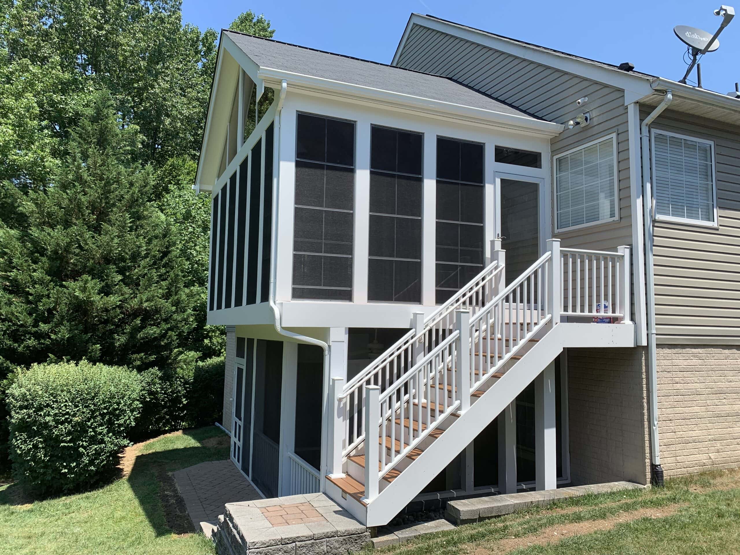 Side view of completed elevated porch with white PVC wrap and Trex railing