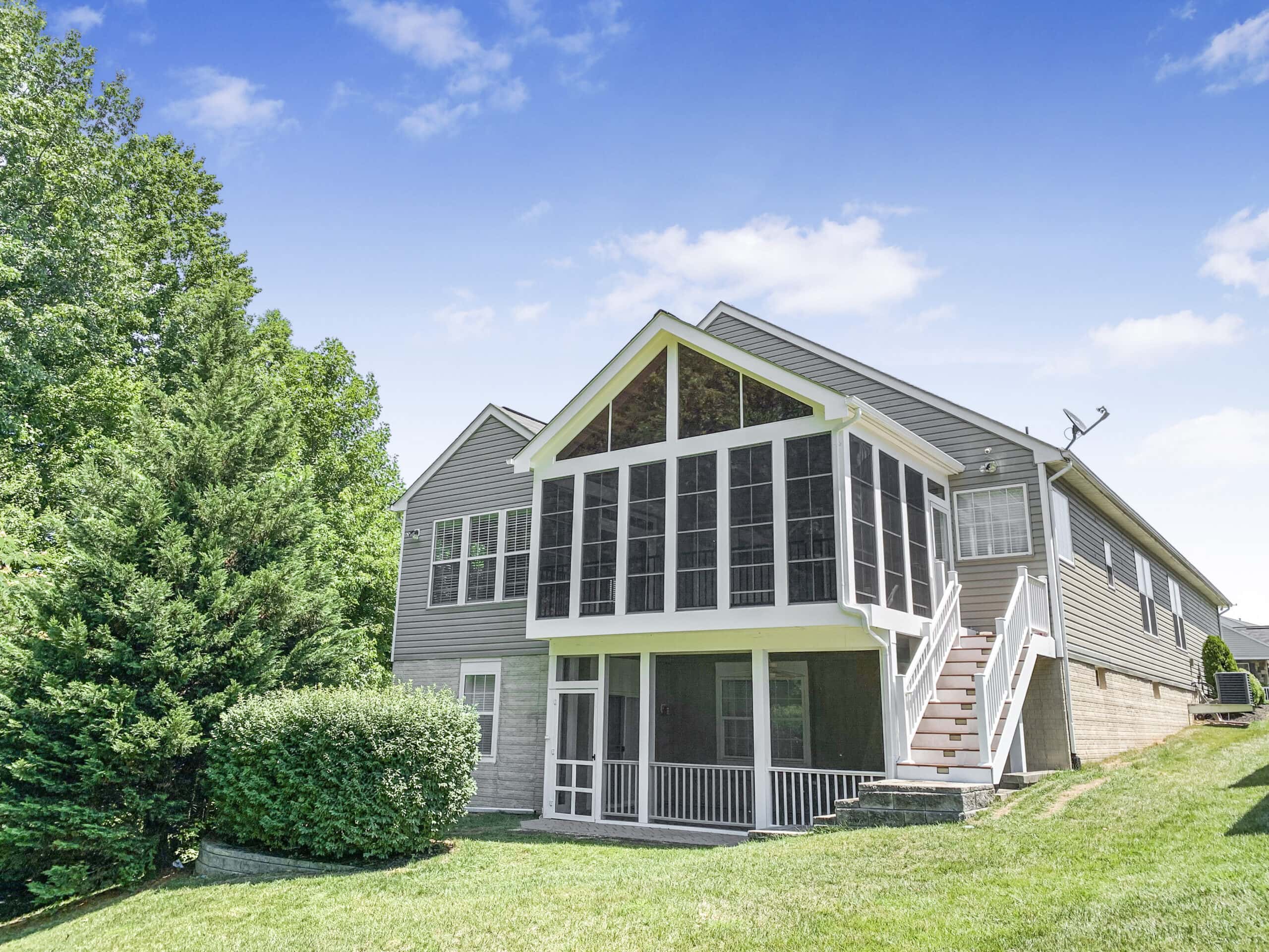 Rear view of completed elevated porch with white PVC wrap and Trex railing