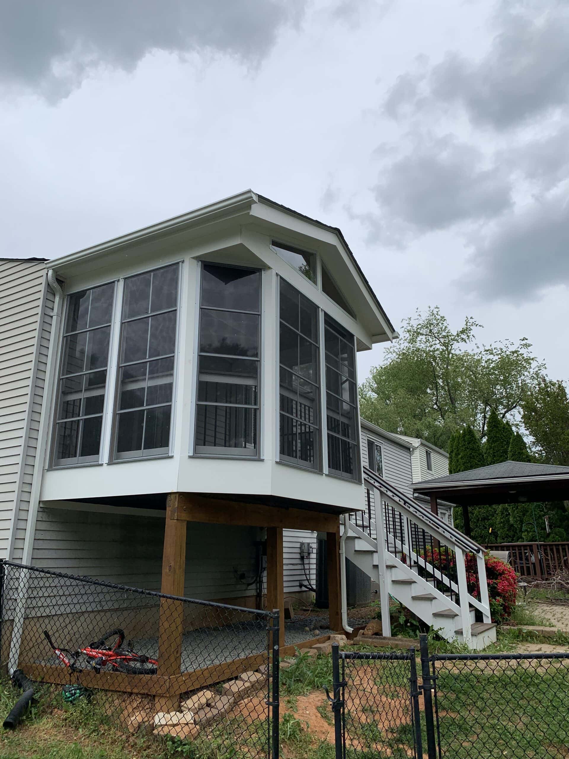 A house with a deck and stairs leading to the second floor.