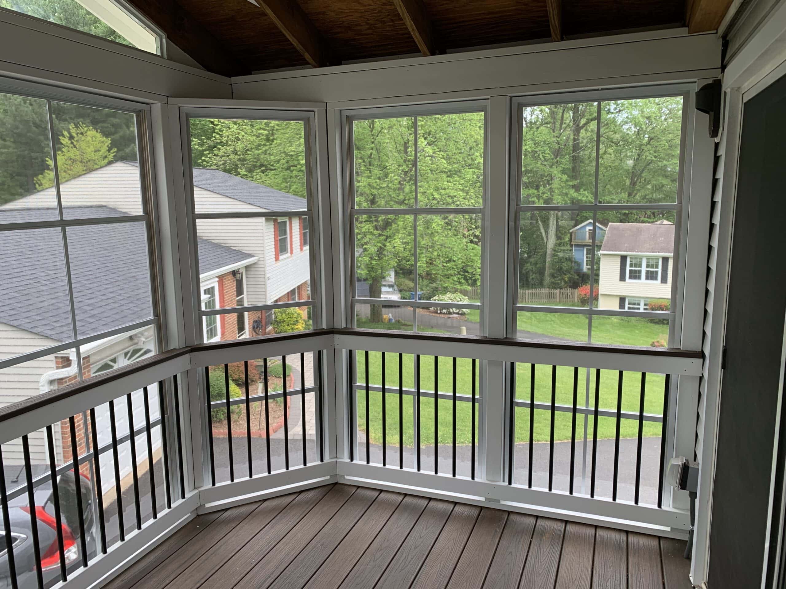 A porch with a balcony and a view of the backyard.