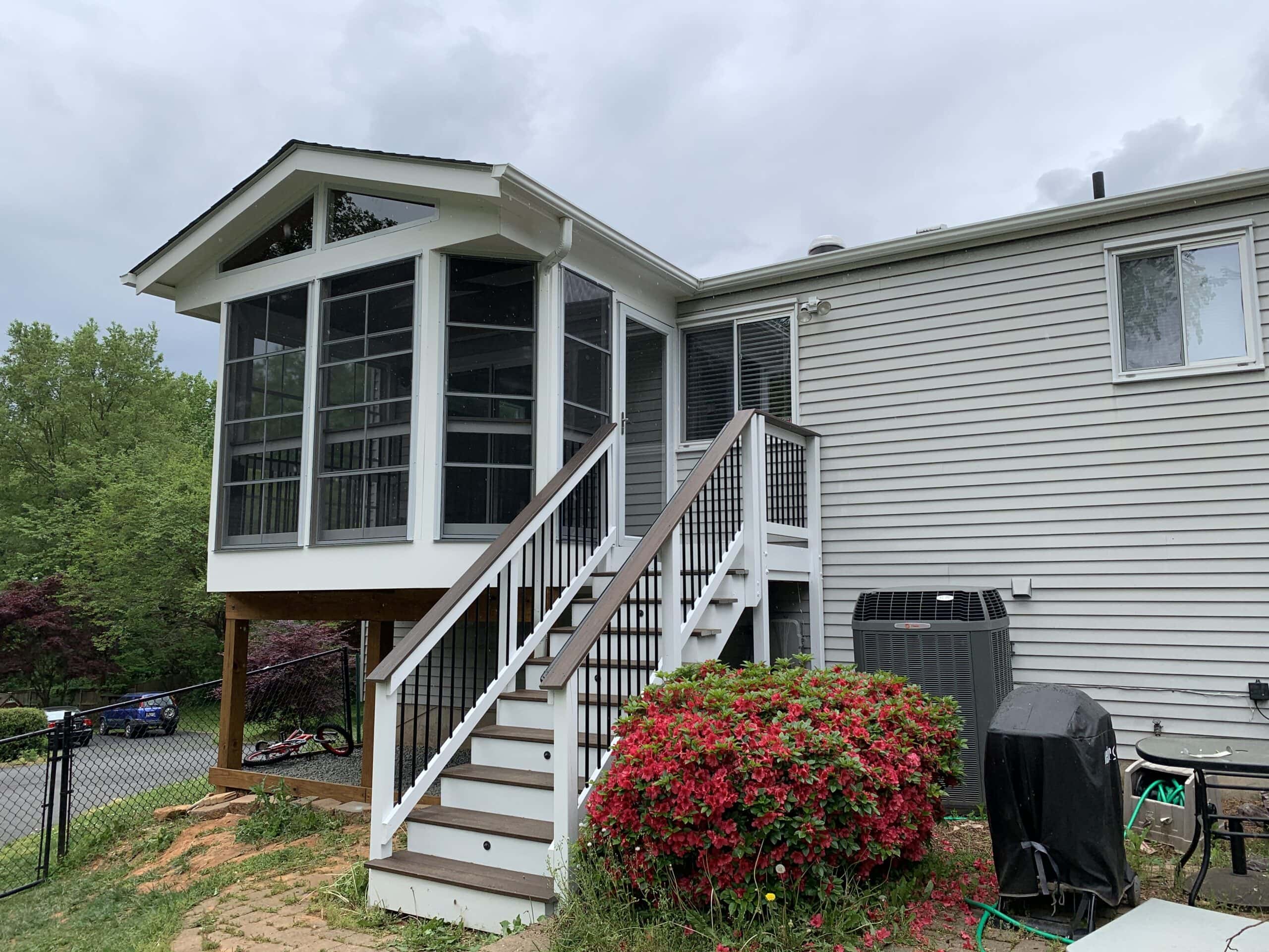 A house with a deck and stairs leading to the front door.