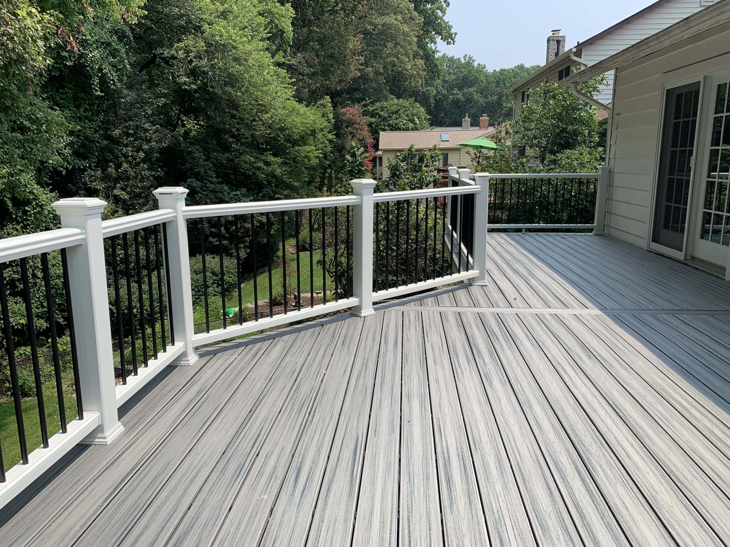 An open-style Trex Transcend railings with black aluminum balusters with Trex Transcend decking in Island Mist