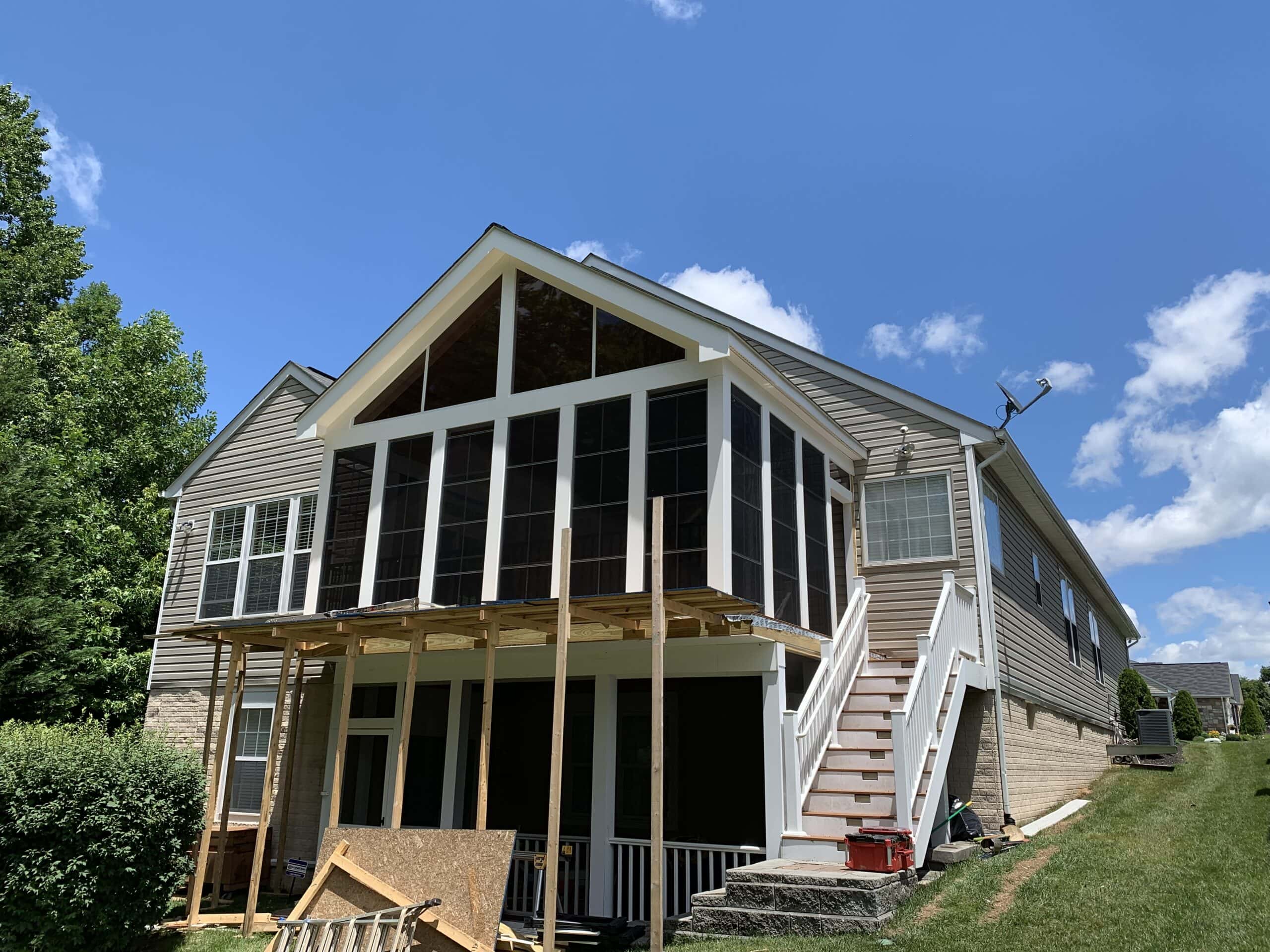 Finished three-season porch with black aluminum railings and full window enclosure