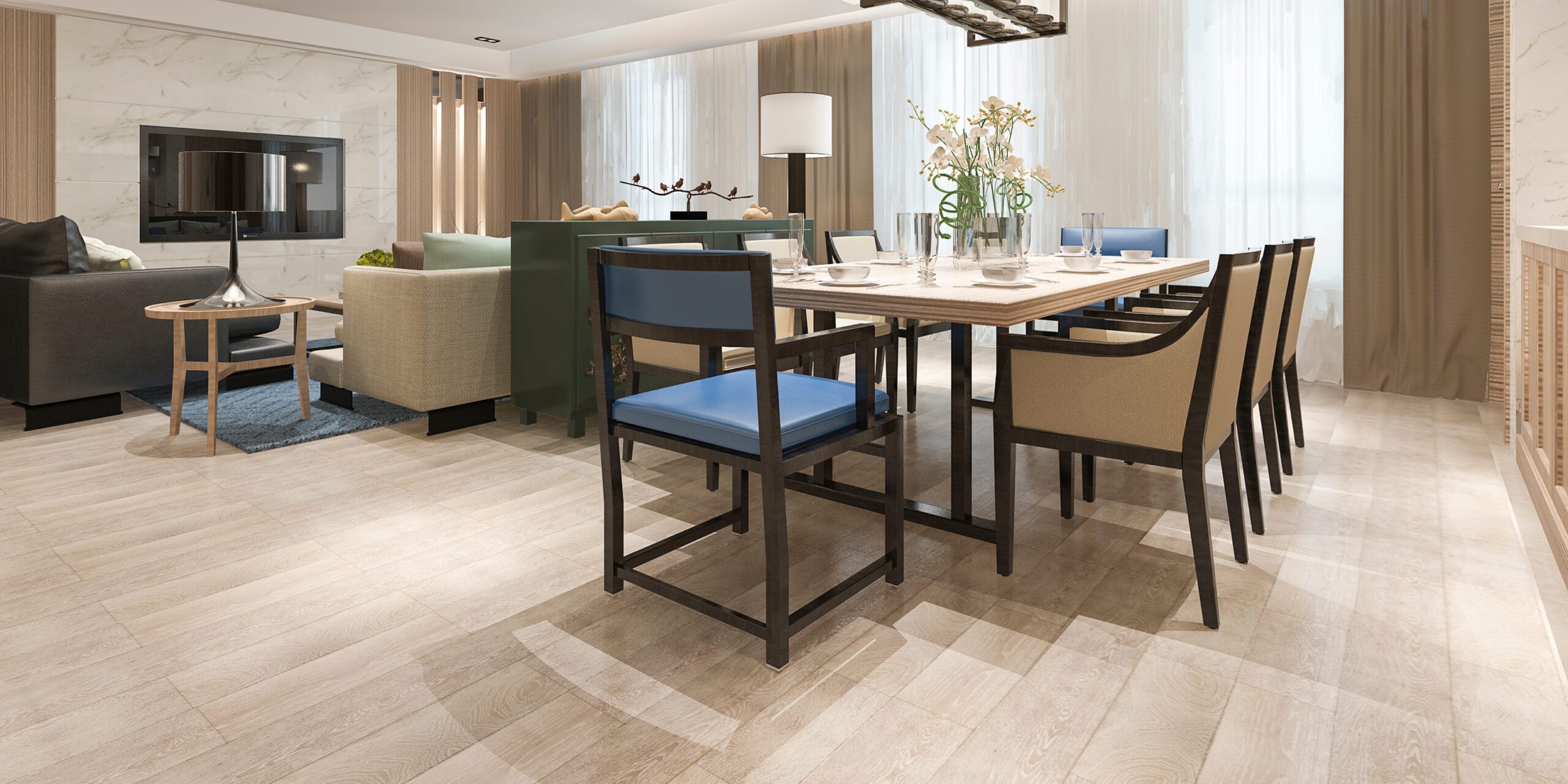 Modern dining and living area with a wooden floor, a dining table set for six with beige and blue chairs, and a sofa set in the background. Expertly crafted by a general contractor in Northern VA, natural light fills the space through sheer curtains.