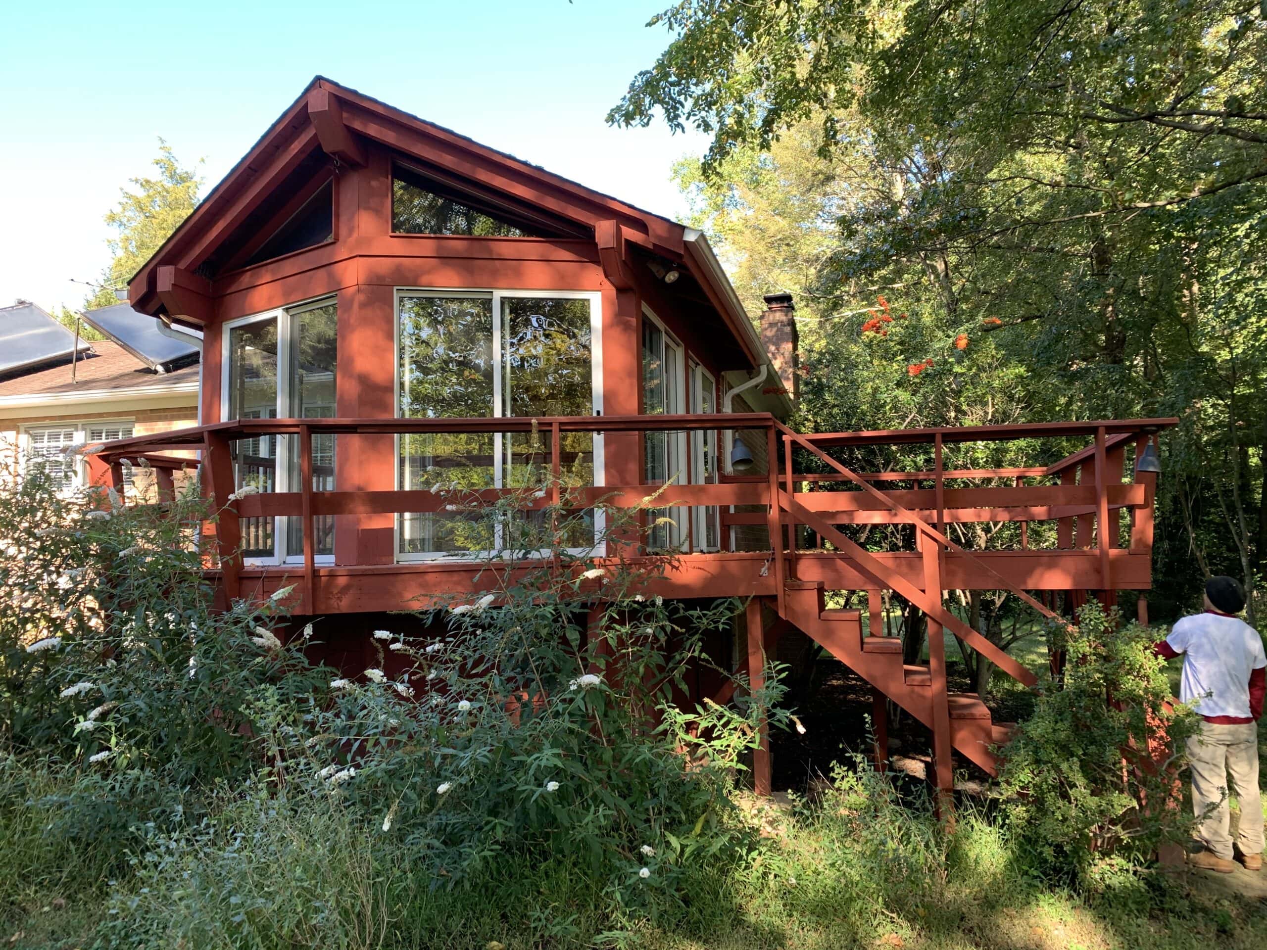 View of the original outdated backyard addition with a red-painted wood structure