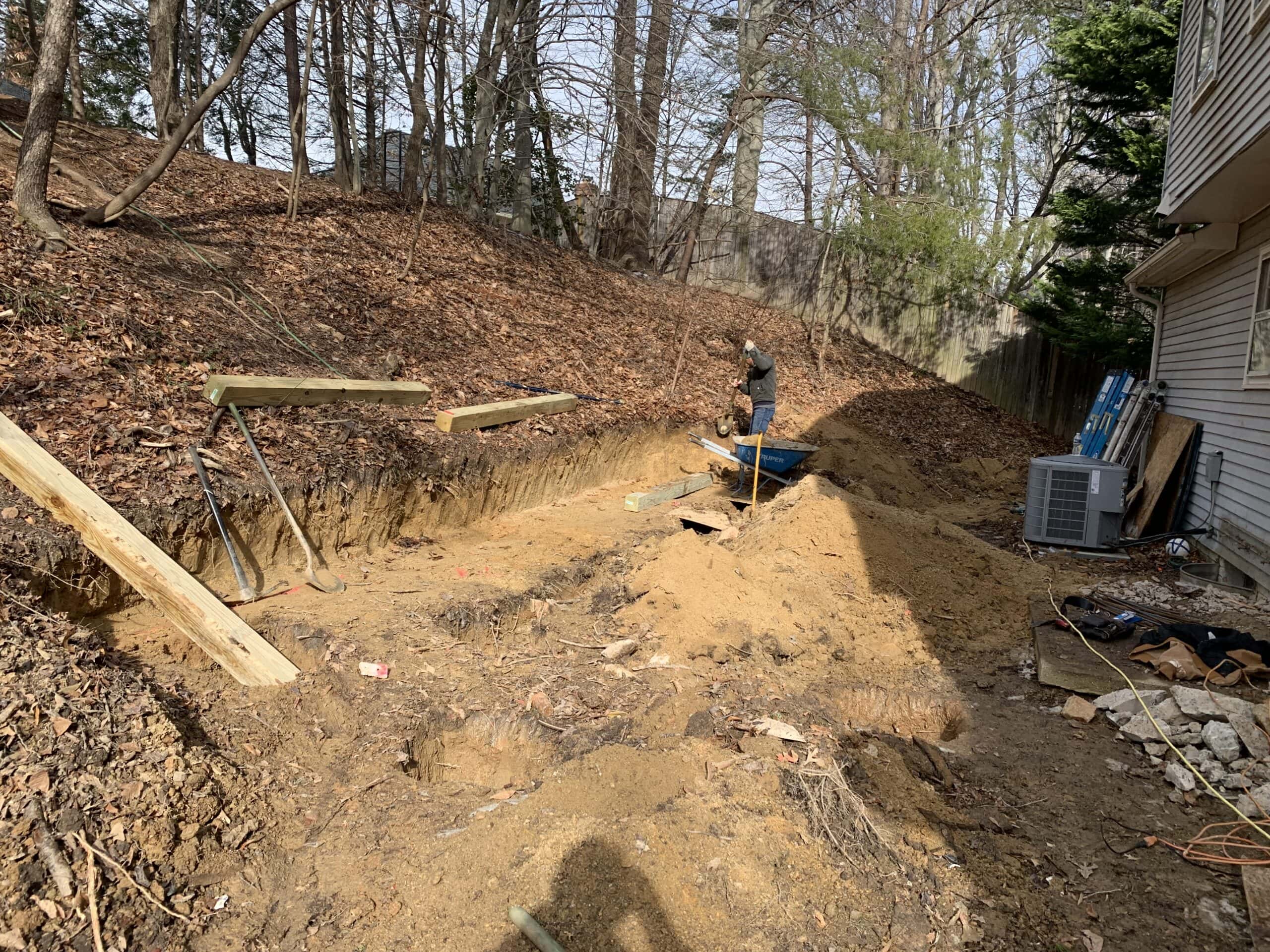 Excavation work in progress to carve out a flat area for the new screened-in porch and deck.