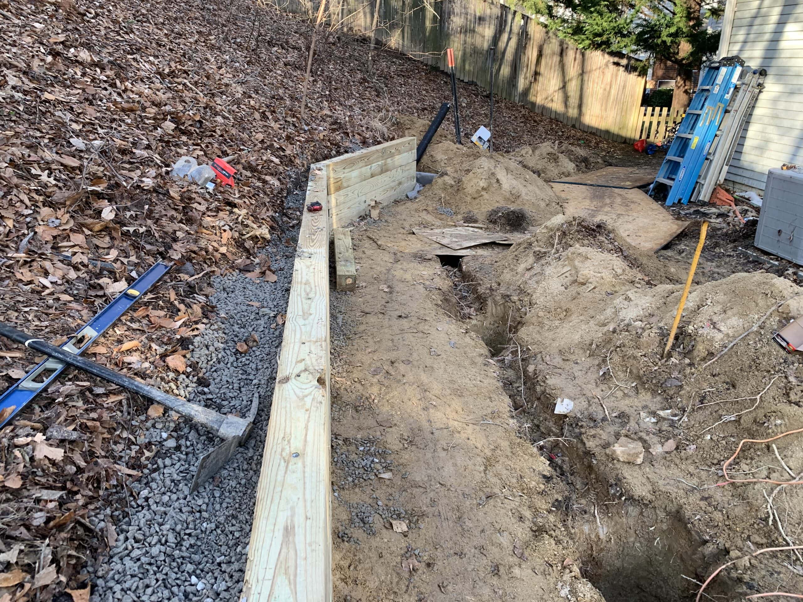 Early stages of grading and forming the retaining wall to support the future structure.