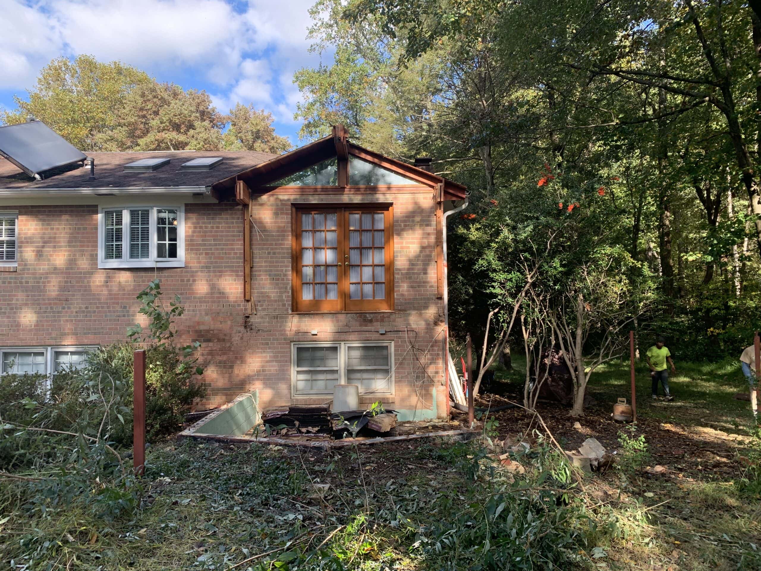 Rear view of the home with the outdated addition completely removed, making way for new construction.