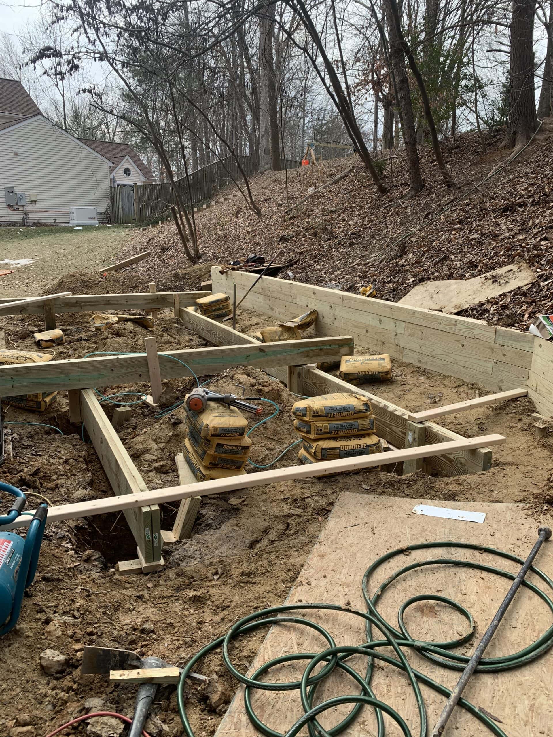 Framing for the deck foundation underway, with materials and tools on site.