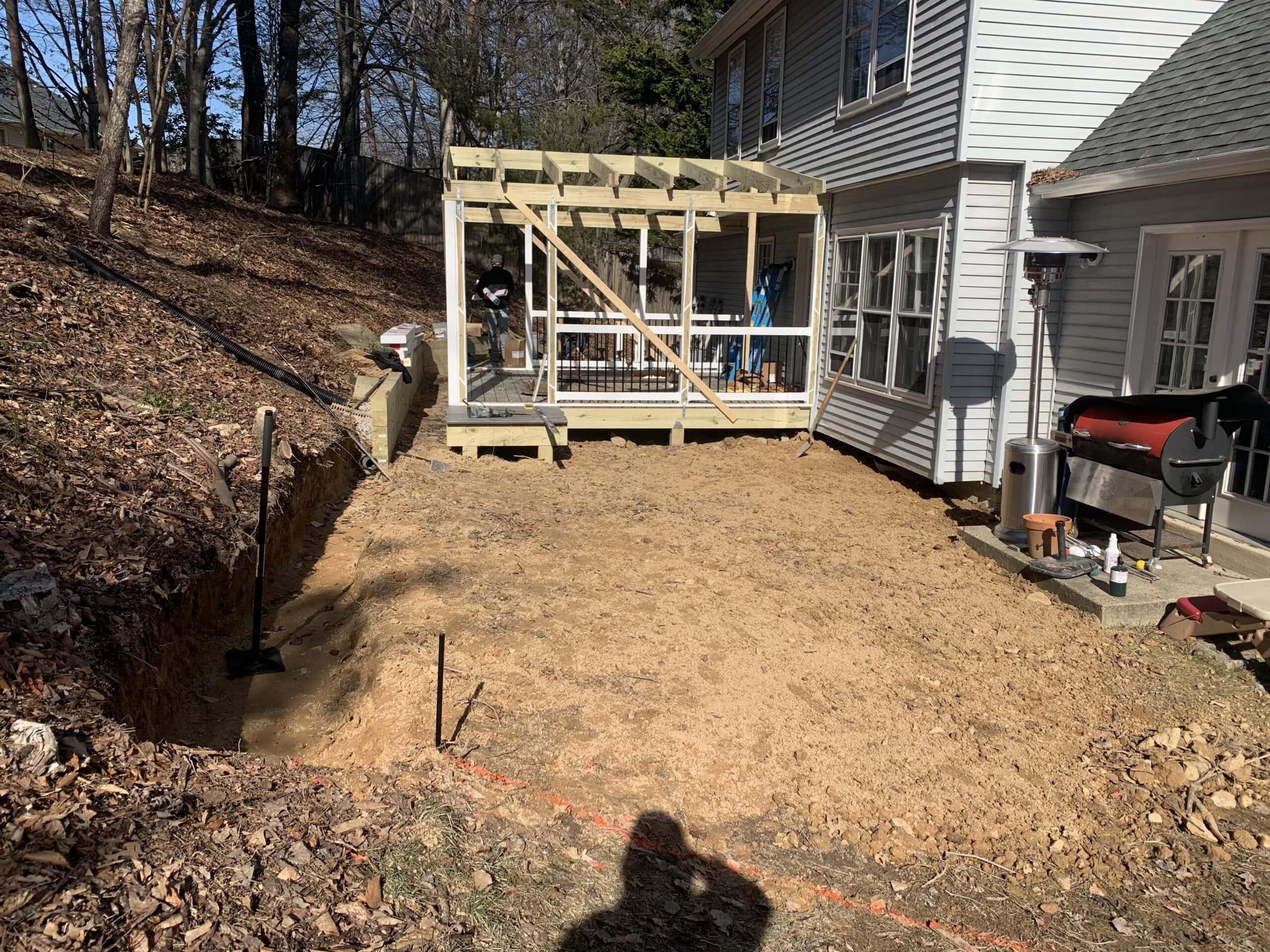 View of the deck and screened-in porch framing connected to the house, showing how the build integrates with the backyard.