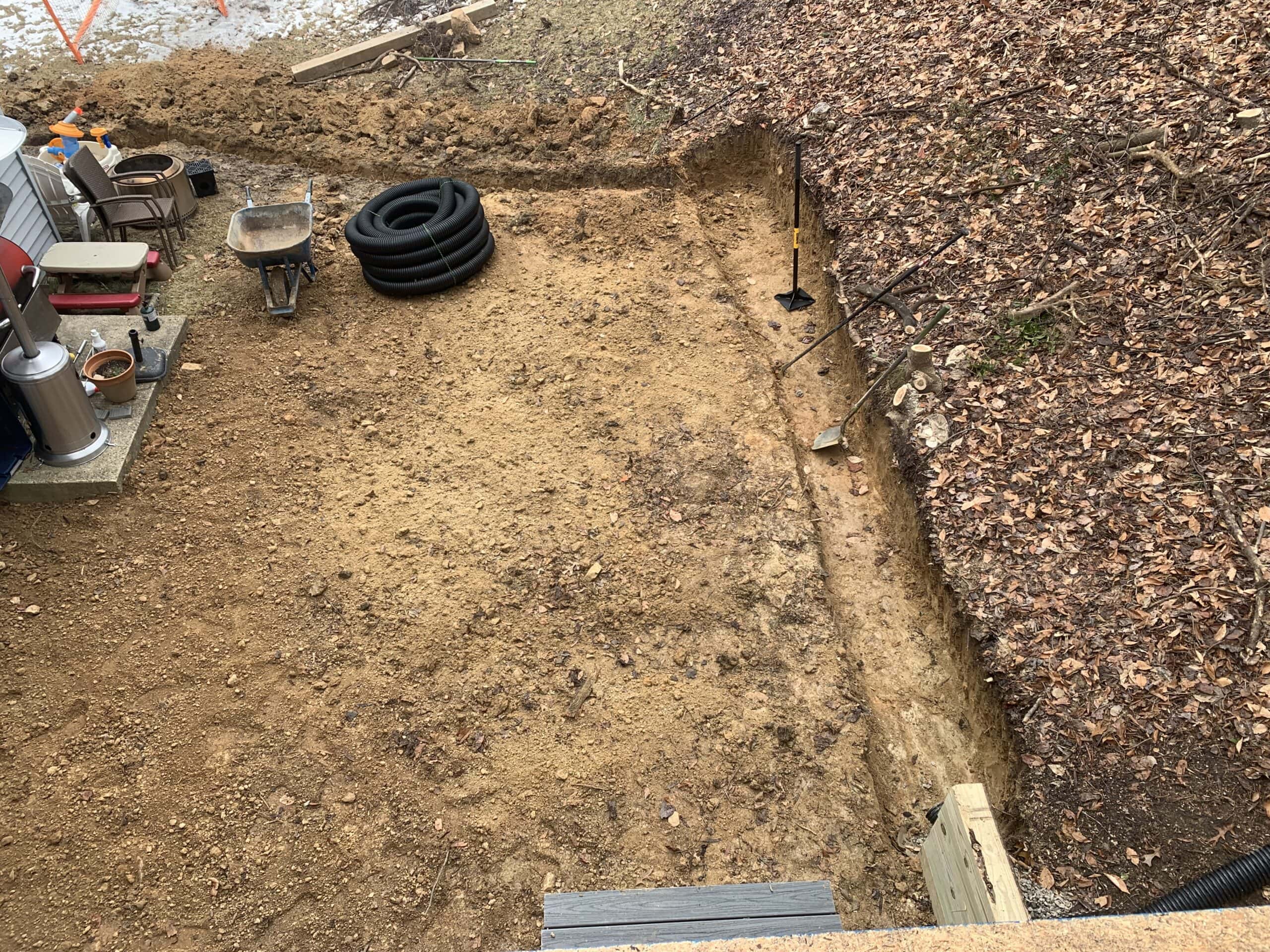 Cleared and graded area next to the new deck, preparing for additional landscaping or hardscaping.