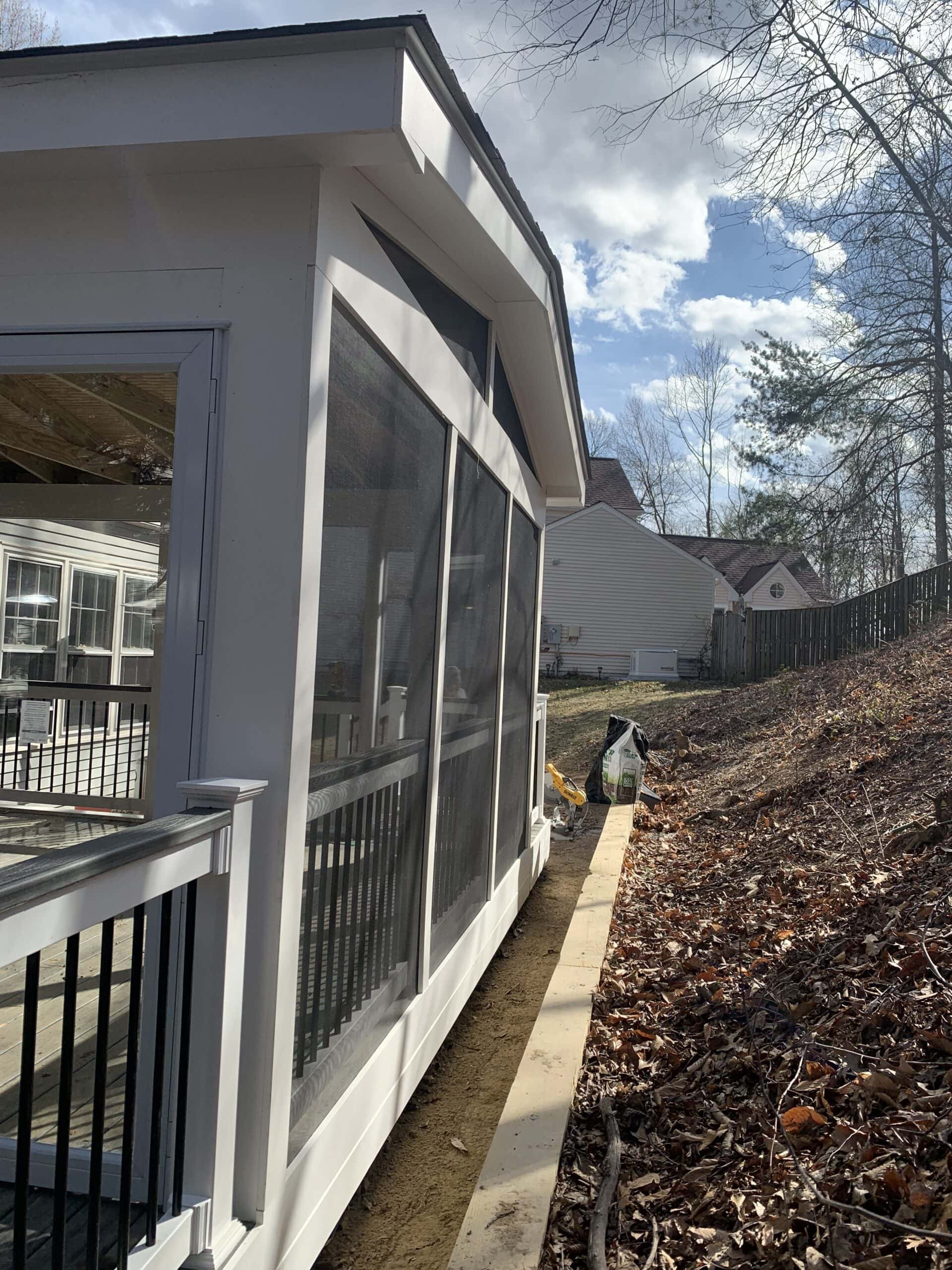 Completed screened-in porch with white trim and black balusters