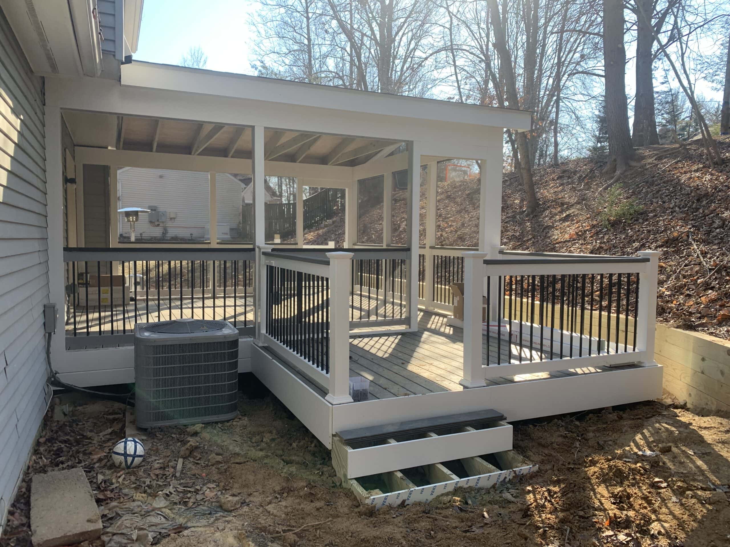 Close-up of the finished screened-in porch and Trex deck with sleek black balusters and crisp PVC fascia.