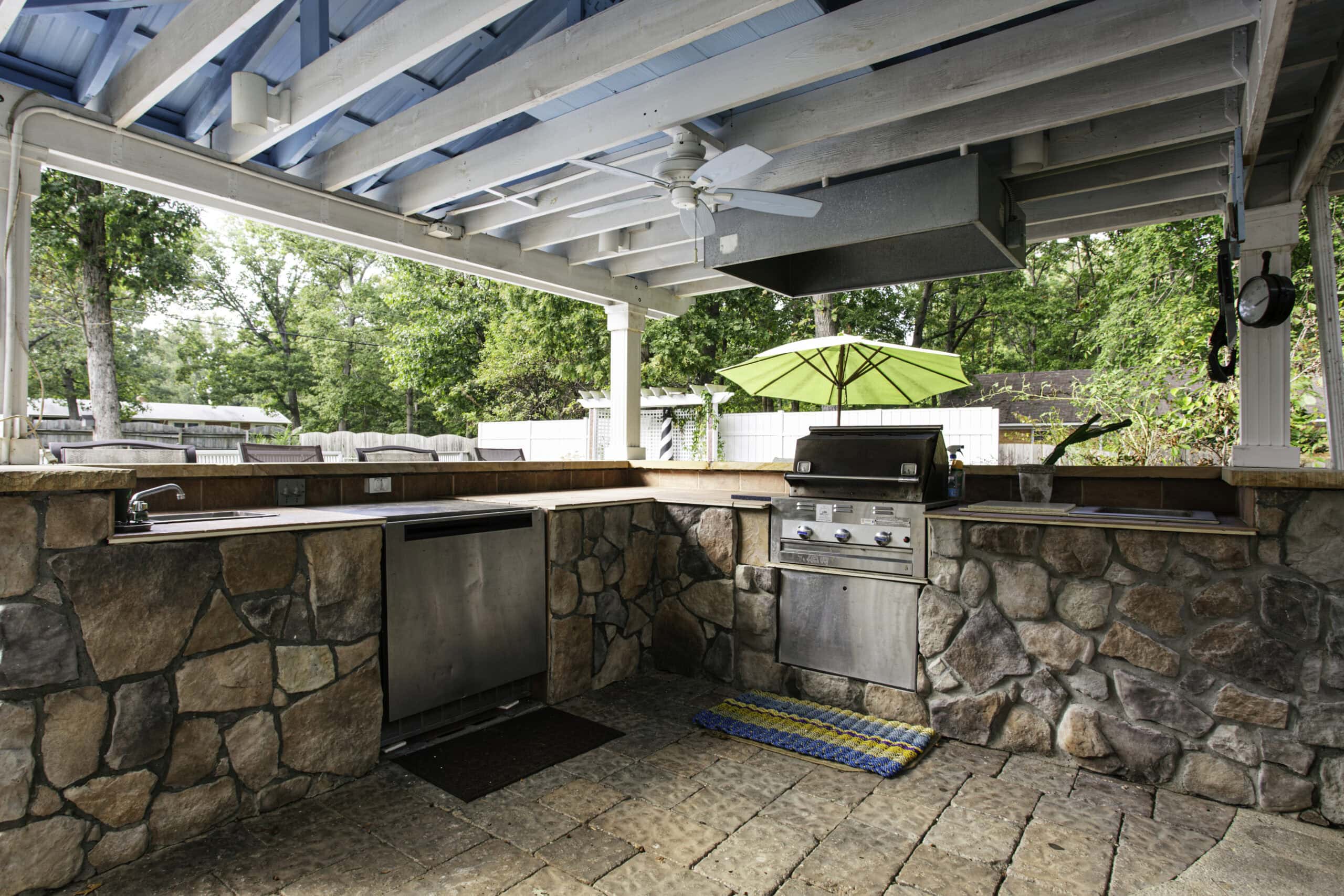 Outdoor Kitchen With Stone Countertops And Appliances.